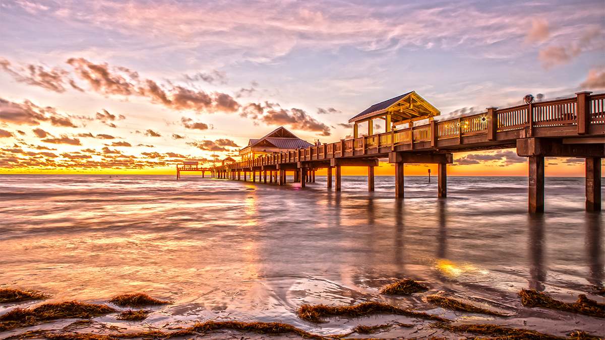 Sunset over Clearwater Beach with the pier in the middle and lots of clouds near Tampa, Florida, USA